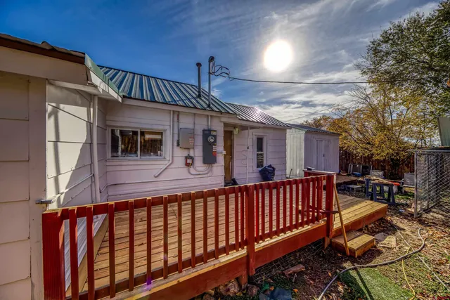 a view of a house with barbeque and wooden stairs