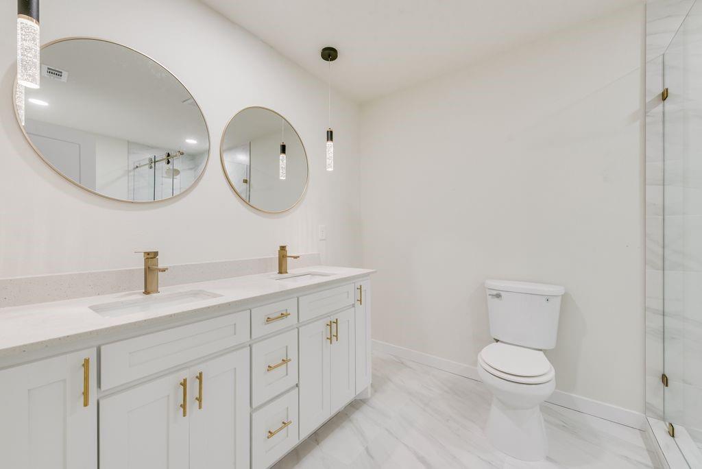 3414 Vilbig Road Dallas, TX 75212 - Photo 22 of 27 a bathroom with a toilet a sink a mirror and vanity