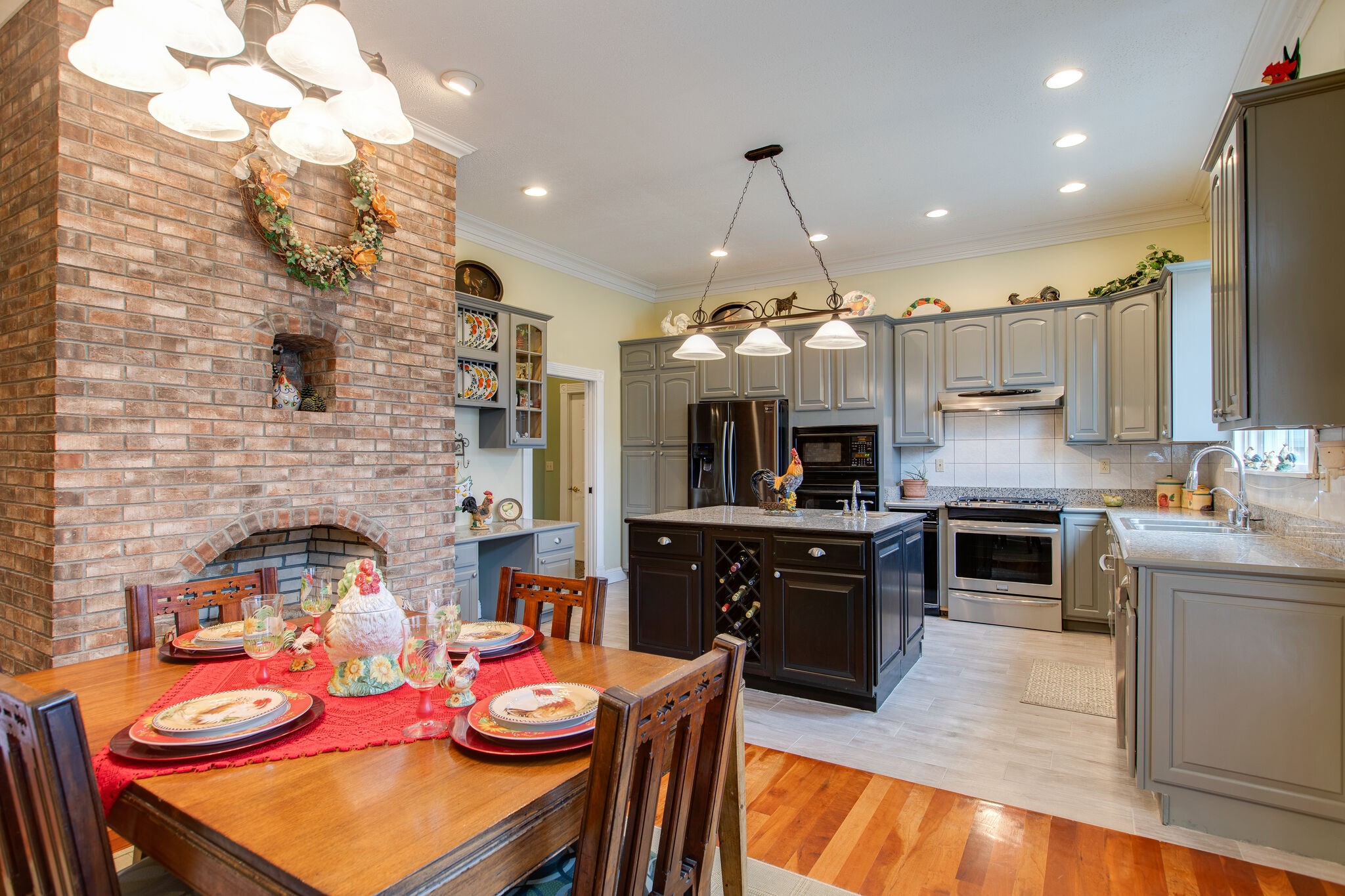 7217 Kingston Road Fairview, TN 37062 - Photo 14 of 50 a kitchen with stainless steel appliances granite countertop a stove top oven a sink a dining table and chairs
