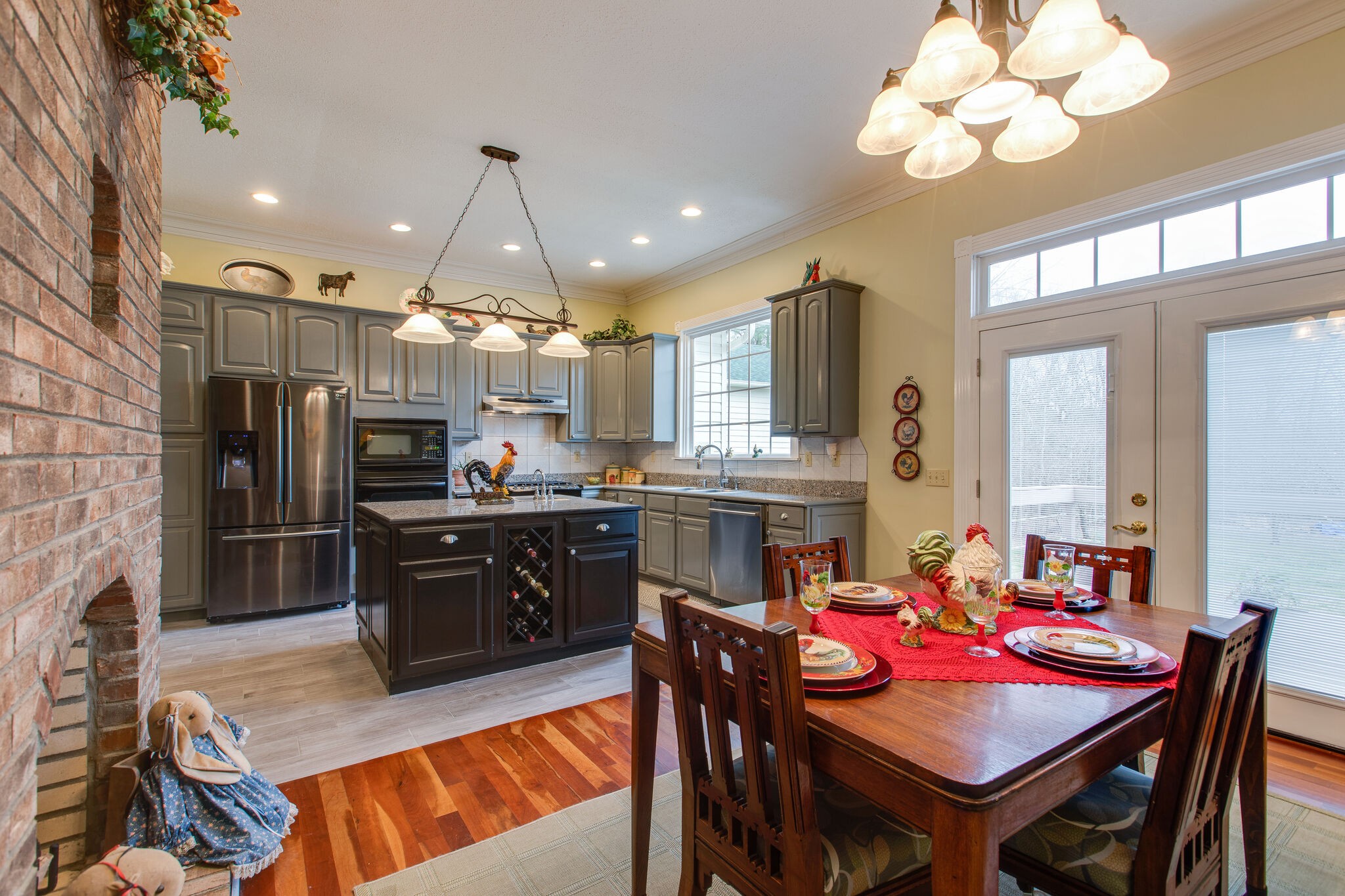 7217 Kingston Road Fairview, TN 37062 - Photo 15 of 50 a kitchen with stainless steel appliances kitchen island granite countertop a refrigerator a stove a sink a dining table and chairs with wooden floor