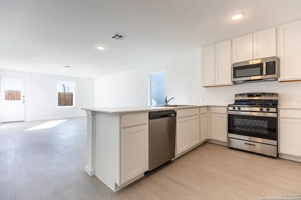 a kitchen with stainless steel appliances white cabinets and a sink
