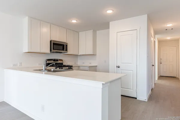 a kitchen with sink a microwave and cabinets