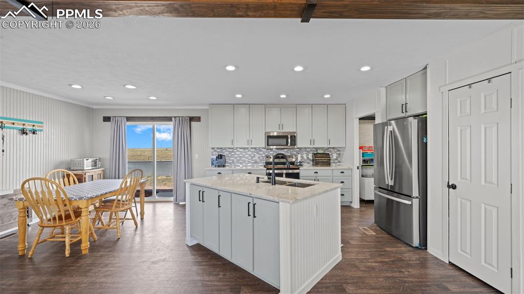 810 Awesome View Yoder, CO 80864 - Photo 6 of 43 a kitchen with stainless steel appliances a table chairs refrigerator and wooden floors