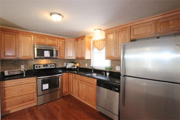 357 West Wrentham Road Cumberland, RI 02864 - Photo 3 of 18 a kitchen with granite countertop stainless steel appliances and wooden cabinets