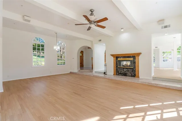 a view of an empty room with a window and a kitchen