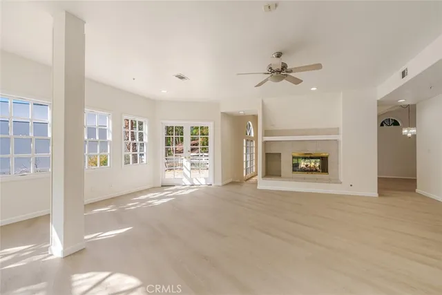 a view of an empty room with a fireplace and a window