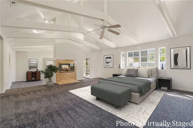 a spacious bedroom with a balcony a bed and a chandelier