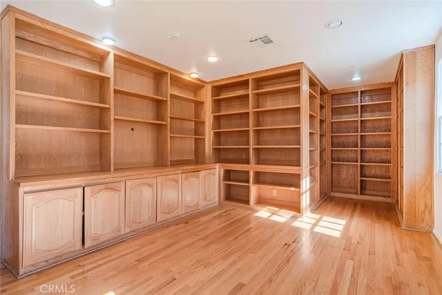 a view of an empty room with a wooden floor and a window