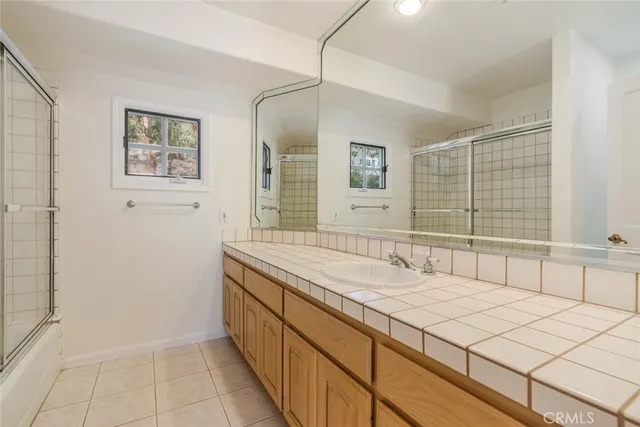 a spacious bathroom with a granite countertop sink a mirror and a shower