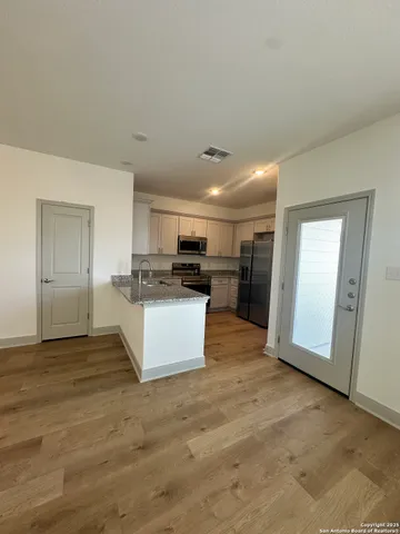a view of kitchen with refrigerator stove microwave and cabinets