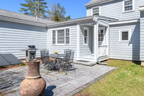 a view of a house with backyard and sitting area