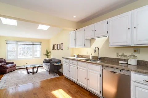 a kitchen with granite countertop a sink and white cabinets