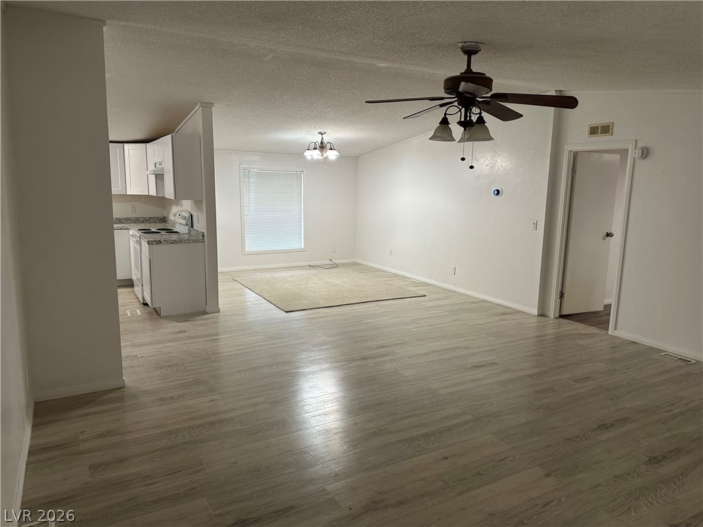 3270 West Simkins Road Pahrump, NV 89060 - Photo 21 of 36 Laminate flooring stretches across the open living space leading toward the kitchen area.