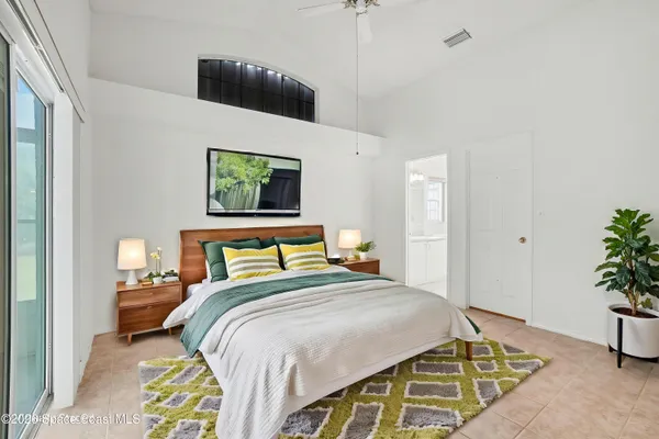 a bedroom with a bed and a potted plant
