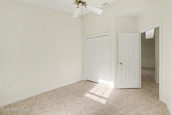 a view of a room with a ceiling fan and closet