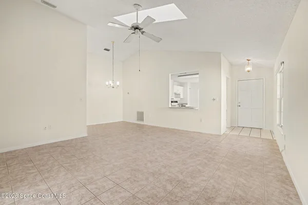 an empty room with fan and windows