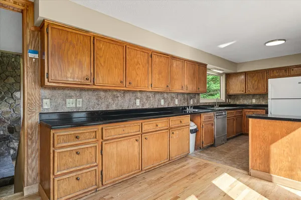 a kitchen with stainless steel appliances granite countertop a refrigerator sink stove and oven