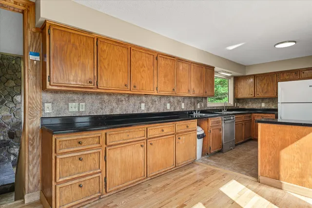 a kitchen with stainless steel appliances granite countertop a refrigerator sink stove and oven