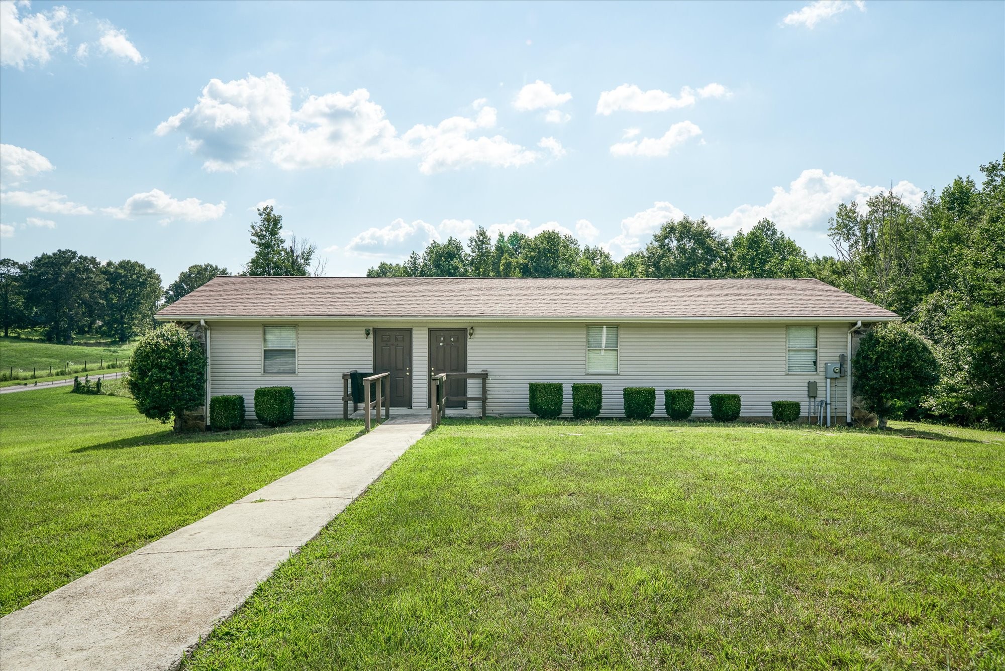3916 Indian Mound Road Sparta, TN 38583 - Photo 37 of 48 a view of a white house in front of a big yard with large trees and plants