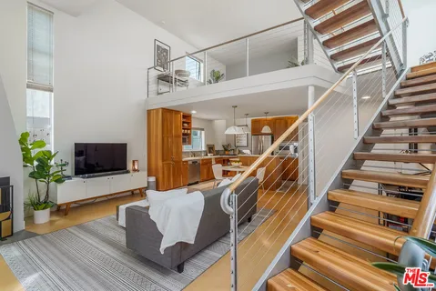 a kitchen with stainless steel appliances granite countertop a refrigerator a sink dishwasher a oven with wooden cabinets and wooden floor