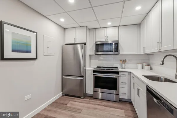 a kitchen with a sink stainless steel appliances and cabinets
