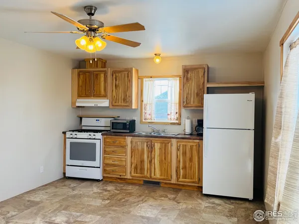 a view of a kitchen with a refrigerator a microwave and a sink