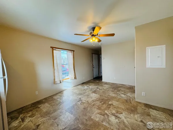a view of an empty room with cabinet and a window