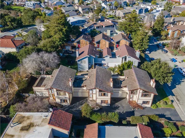 an aerial view of residential houses with outdoor space and parking