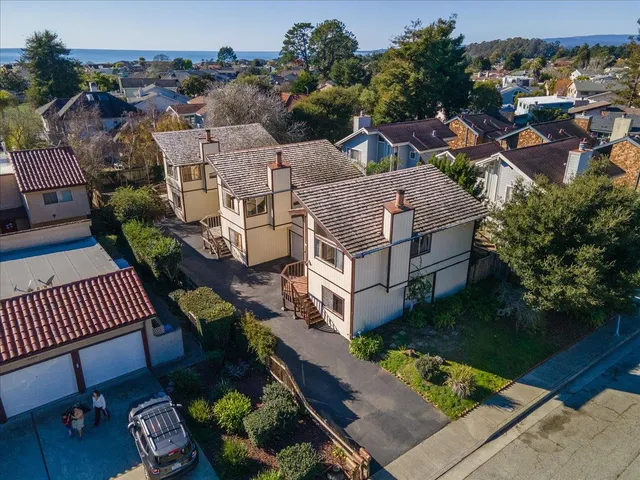 an aerial view of multiple houses with a yard