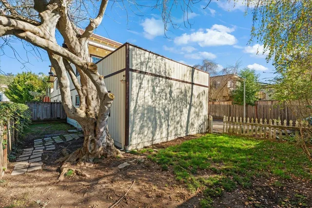 a view of backyard with wooden fence
