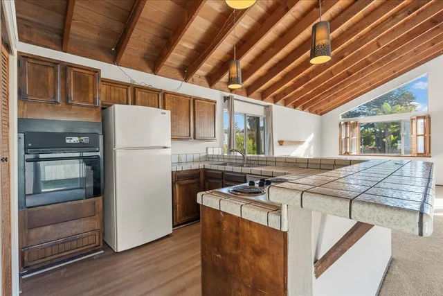a kitchen that has a cabinets a sink and a stove with wooden floor