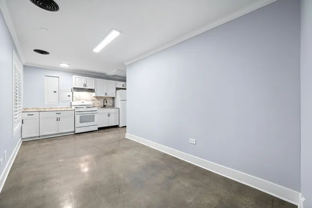 a view of a kitchen with white cabinets and wooden floor