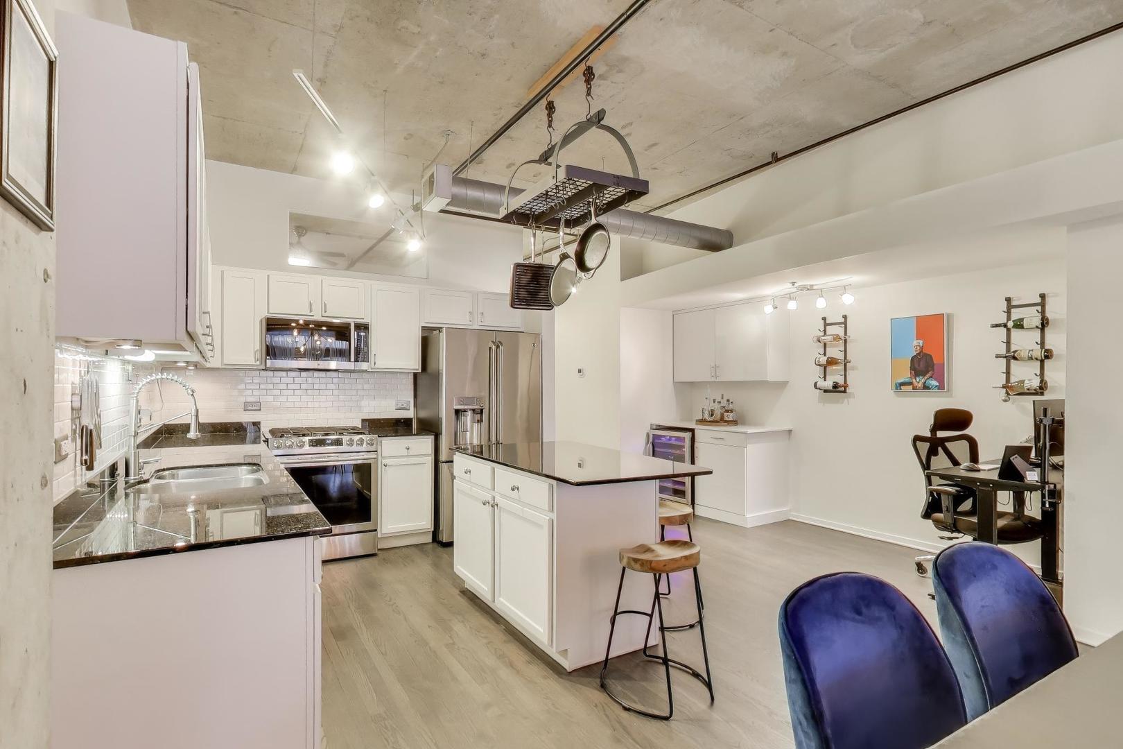 933 West Van Buren Street, Unit 504 Chicago, IL 60607 - Photo 11 of 31 a kitchen with stainless steel appliances granite countertop a sink a stove a refrigerator cabinets and chairs