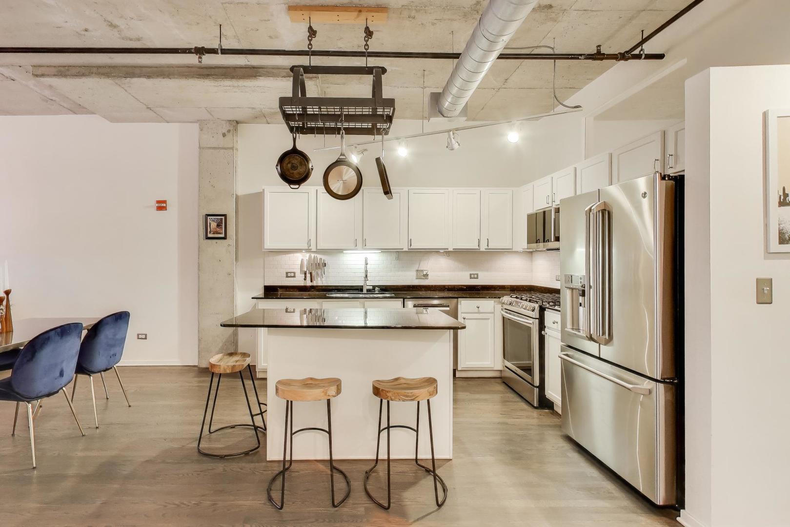 933 West Van Buren Street, Unit 504 Chicago, IL 60607 - Photo 12 of 31 a kitchen with stainless steel appliances granite countertop a sink and a refrigerator
