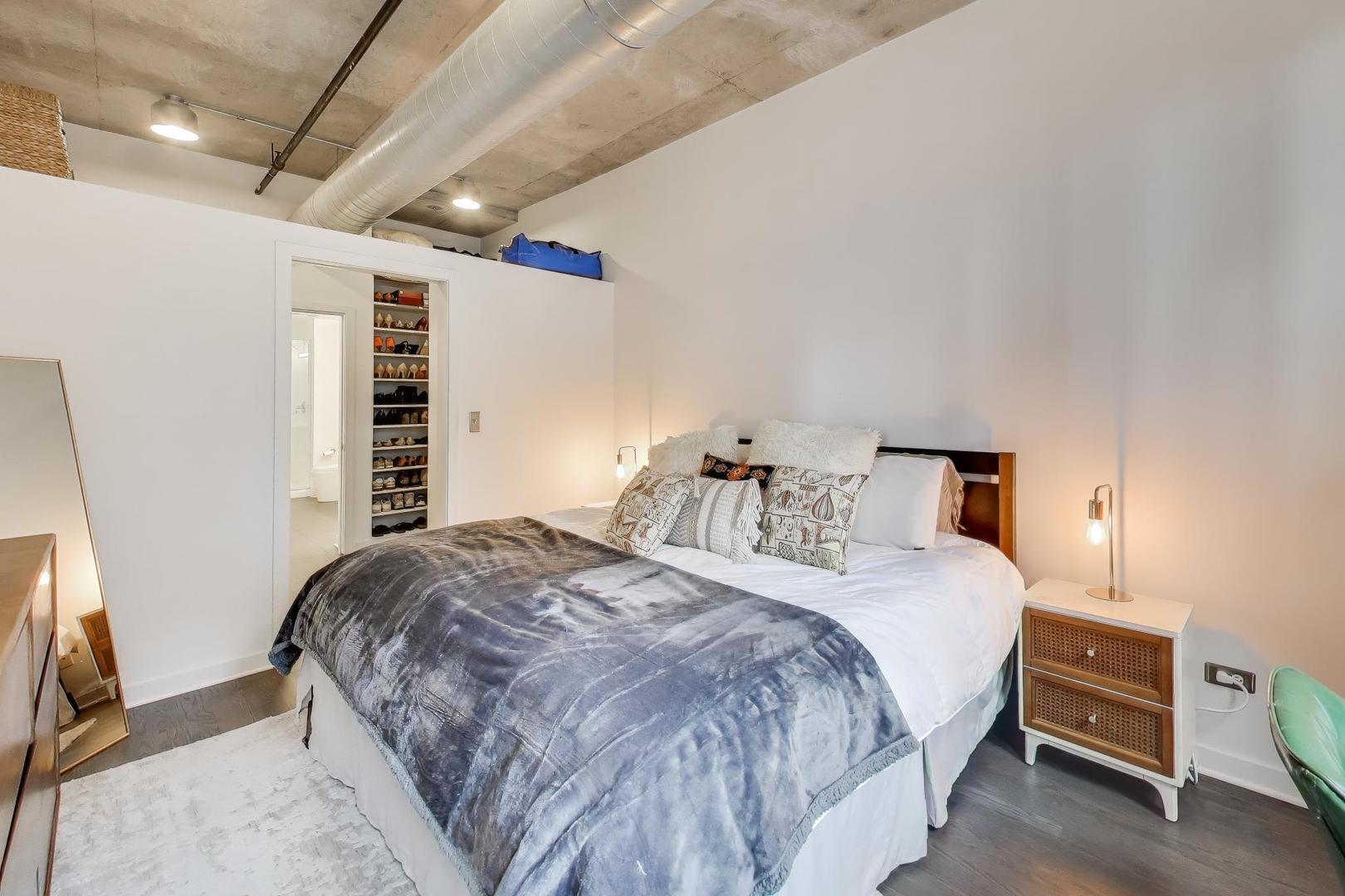 933 West Van Buren Street, Unit 504 Chicago, IL 60607 - Photo 15 of 31 a bedroom with a bed and a flat tv screen on dresser