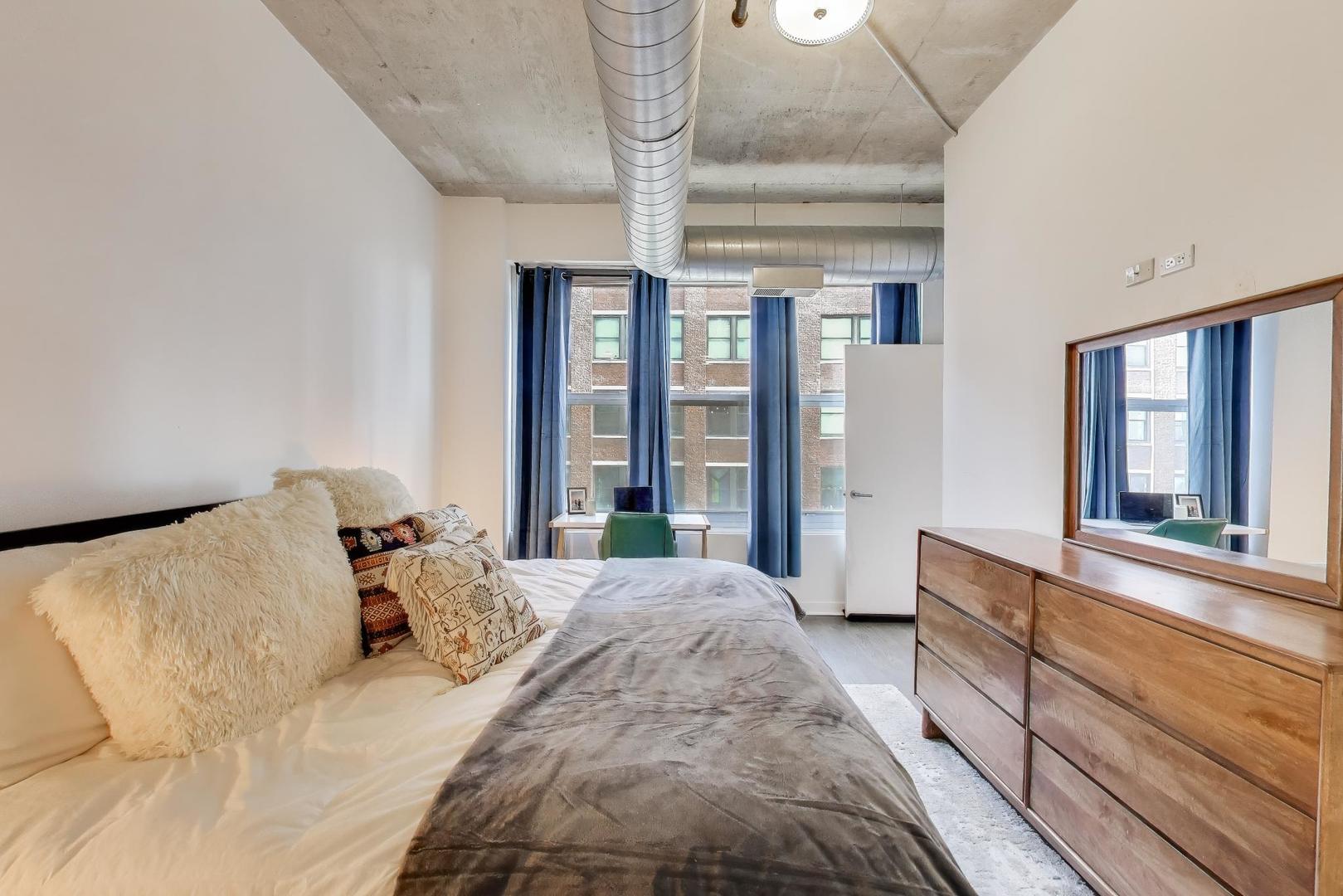 933 West Van Buren Street, Unit 504 Chicago, IL 60607 - Photo 16 of 31 a large bedroom with a large bed and a large window