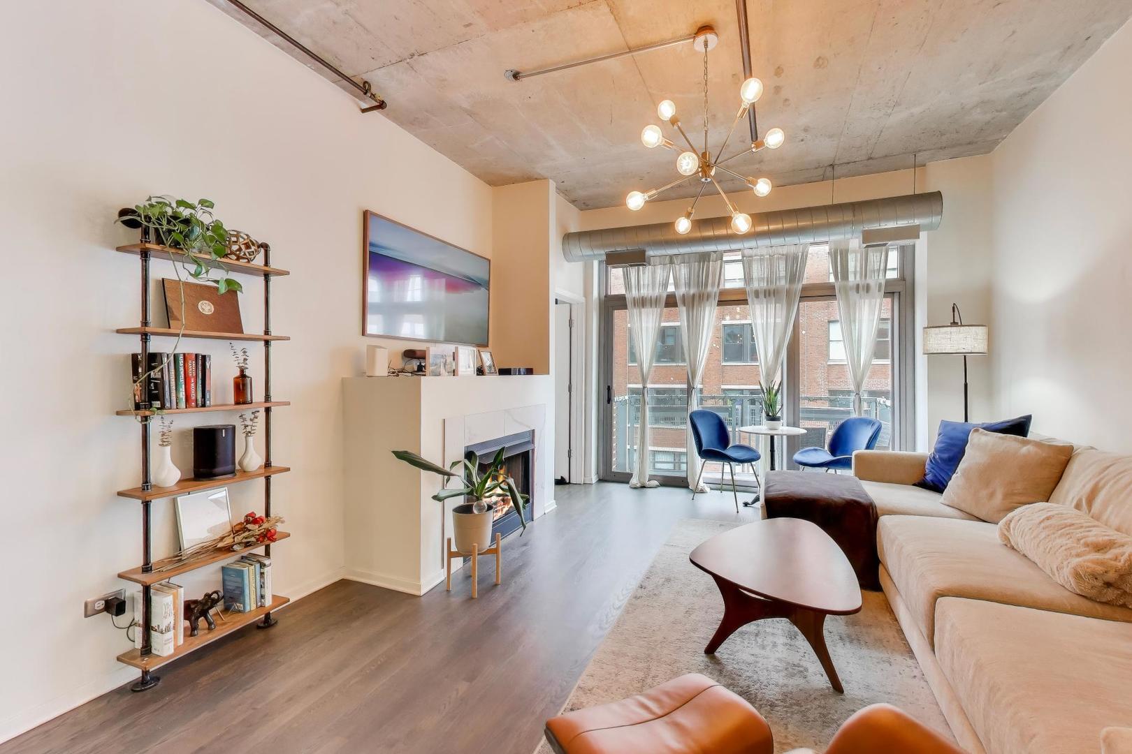 933 West Van Buren Street, Unit 504 Chicago, IL 60607 - Photo 7 of 31 a living room with furniture a flat screen tv and a floor to ceiling window