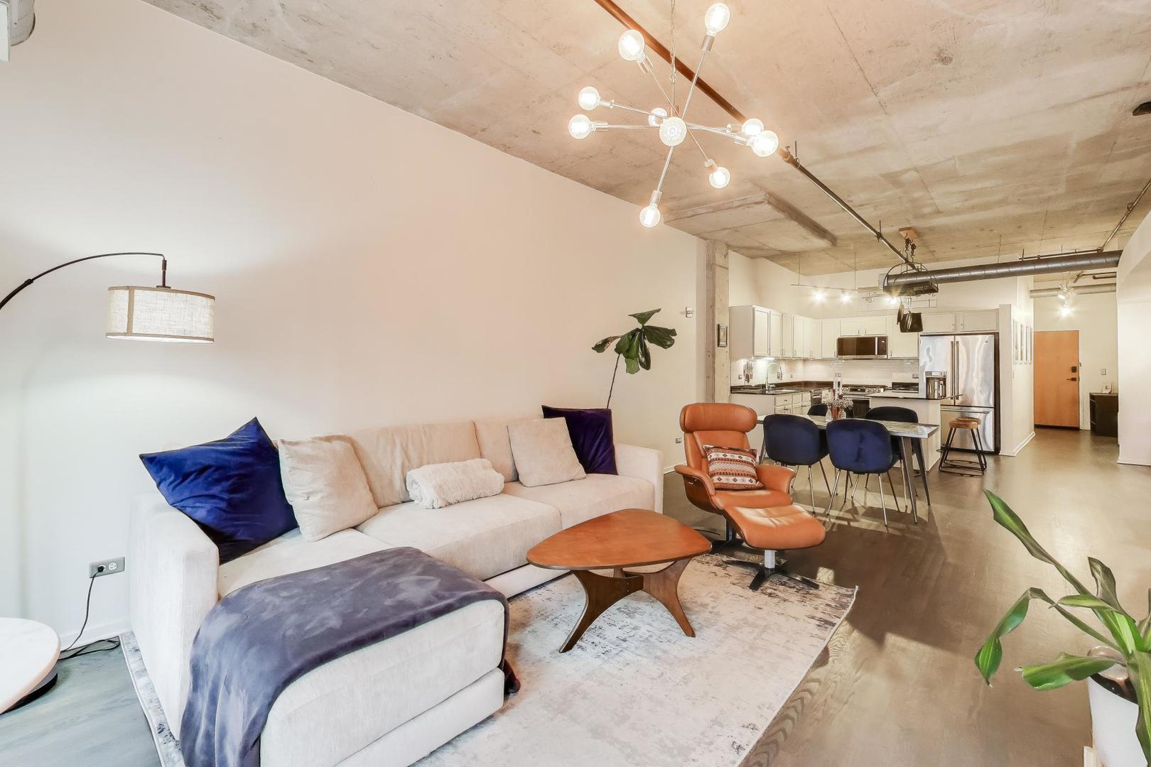 933 West Van Buren Street, Unit 504 Chicago, IL 60607 - Photo 8 of 31 a living room with furniture and a chandelier