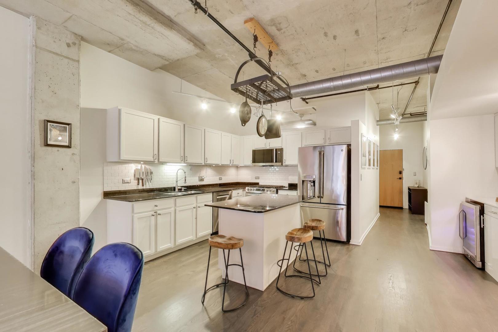 933 West Van Buren Street, Unit 504 Chicago, IL 60607 - Photo 10 of 31 a kitchen with stainless steel appliances granite countertop a refrigerator and a stove top oven