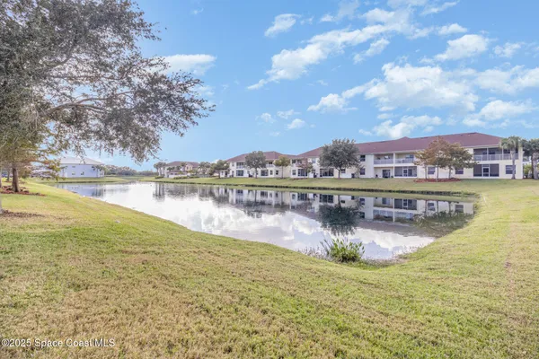 an aerial view of residential houses with outdoor space and lake view