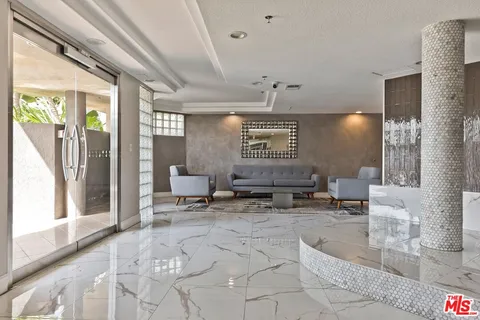 a lobby with furniture and a chandelier