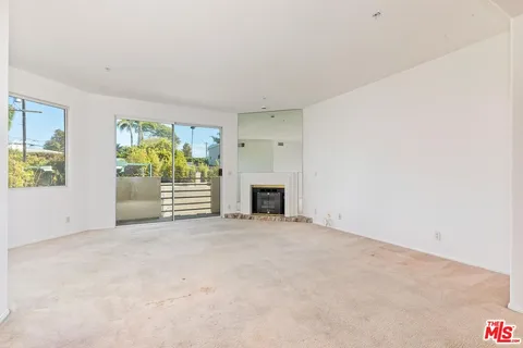 a view of empty room with fireplace and window