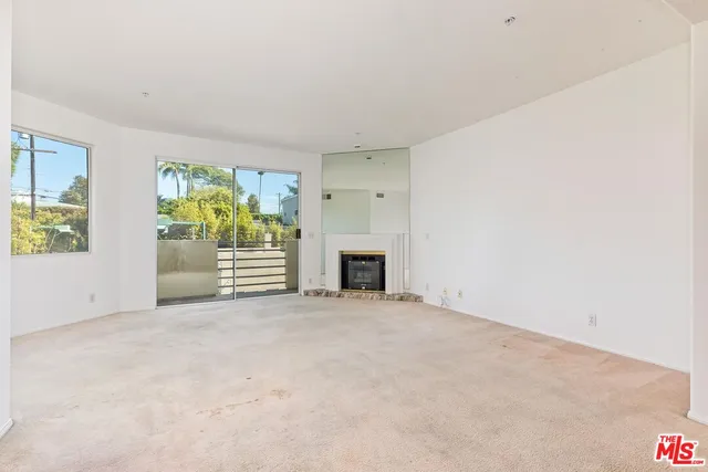 a view of empty room with fireplace and window