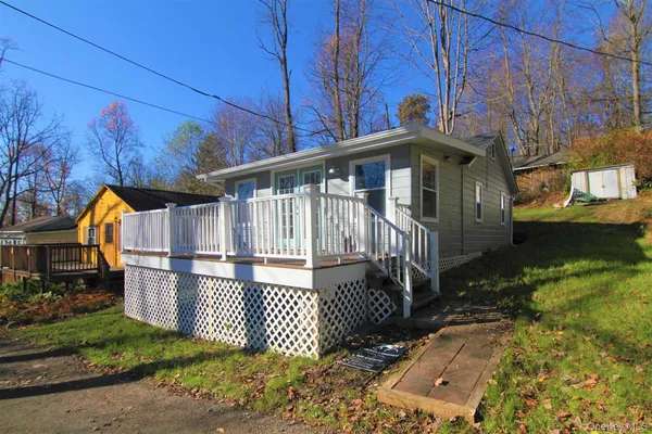 a view of a house with a small yard and wooden fence