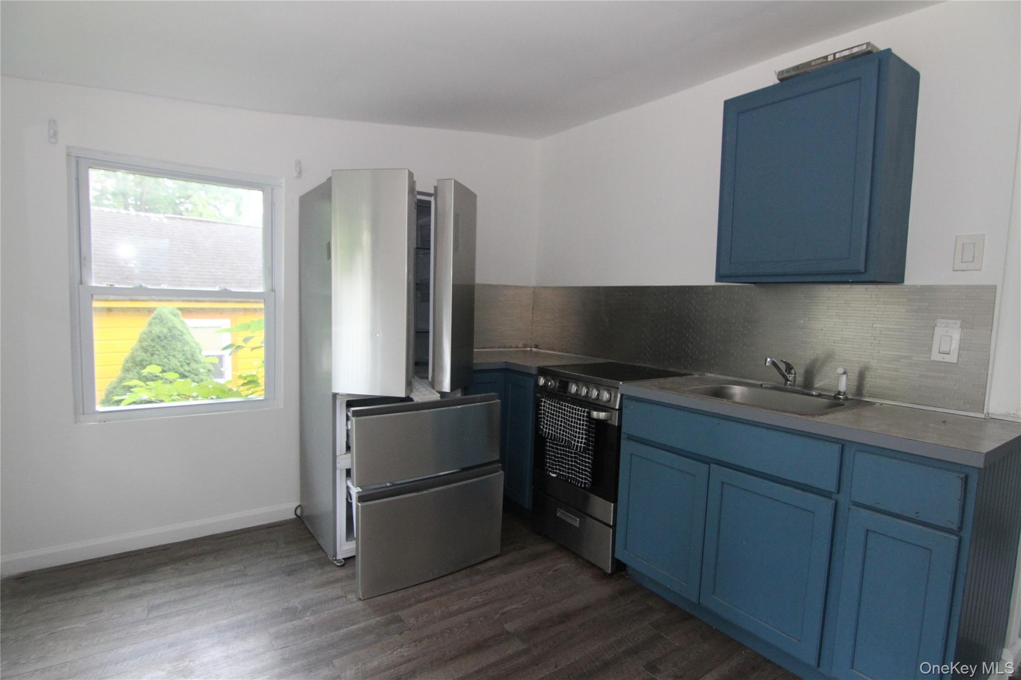 71 Miller Road, Unit 13 Hopewell Junction, NY 12533 - Photo 13 of 28 a kitchen with stainless steel appliances granite countertop a refrigerator a sink a stove white cabinets and wooden floor