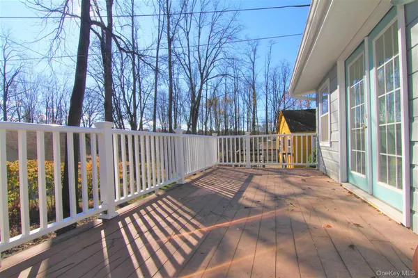 a view of backyard with wooden fence and large trees