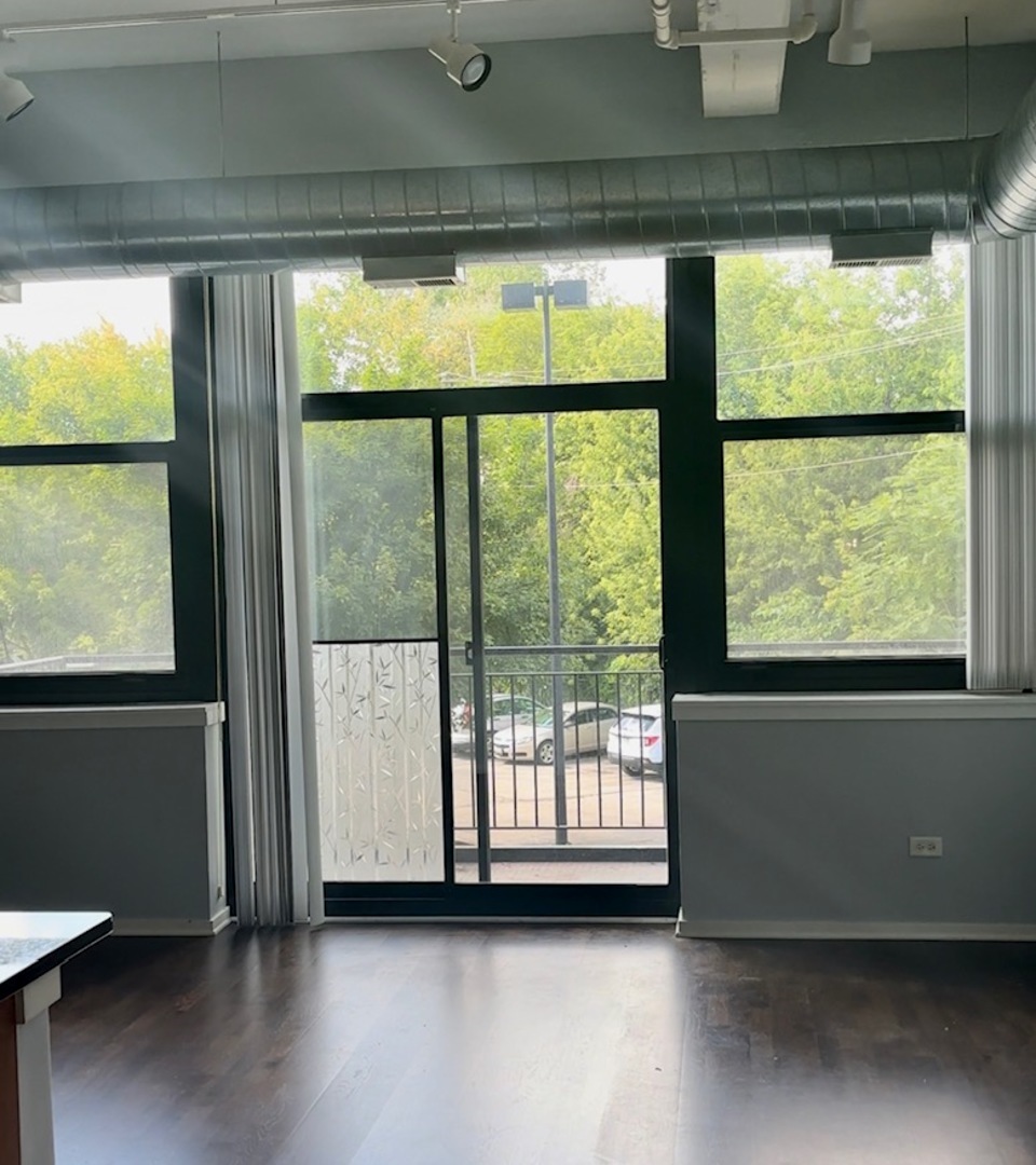 2323 West Pershing Road, Unit 222 Chicago, IL 60609 - Photo 8 of 16 a view of an empty room with wooden floor and a window