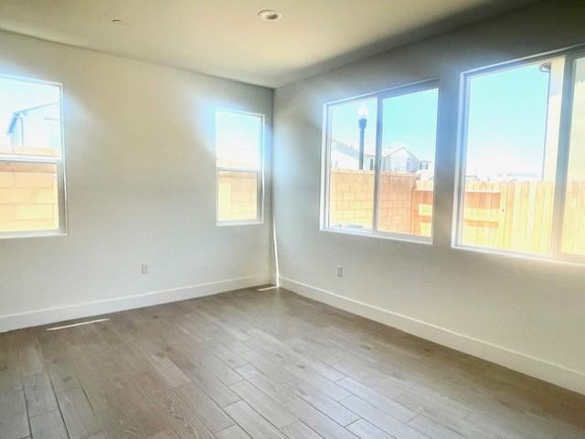 846 Huckleberry Road Madera, CA 93636 - Photo 7 of 12 an empty room with wooden floor and windows