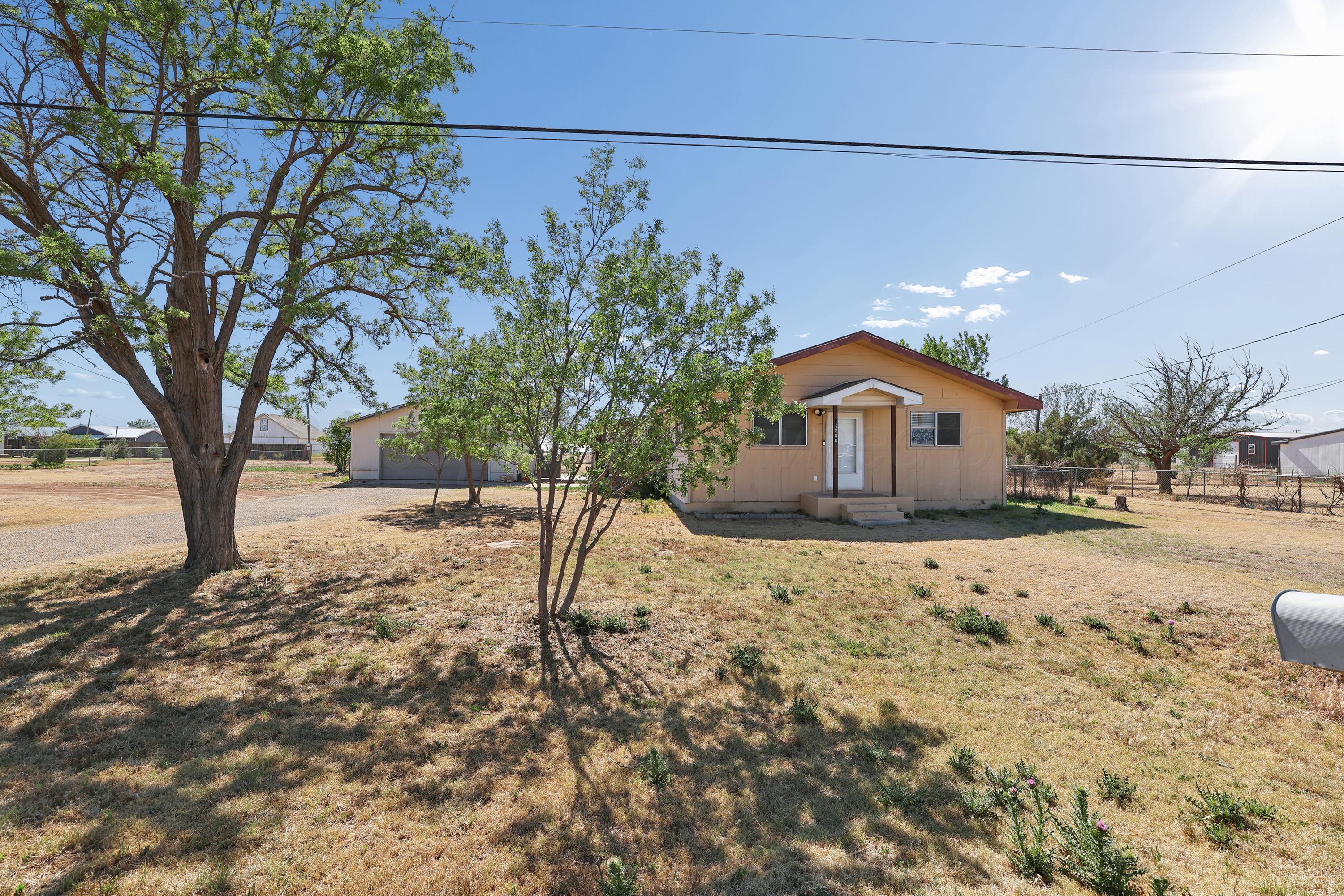 14200 Savannah Road Amarillo, TX 79118 - Photo 34 of 34 a backyard of a house with wooden fence and large trees
