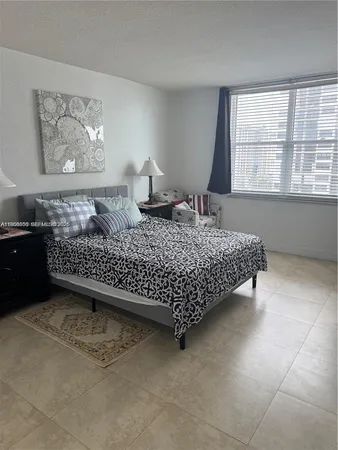 a bedroom with a bed dresser and window